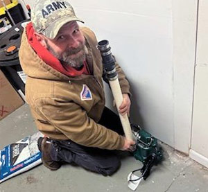 Plumber installing a Zoeller sump pump in a Southeastern Pennsylvania home